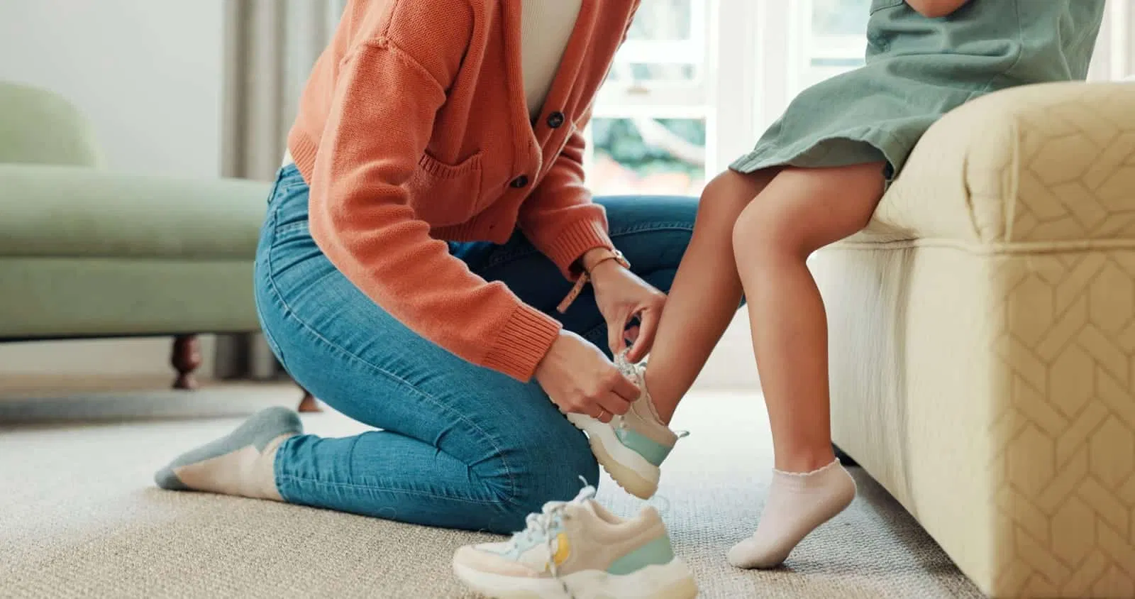 A mother dresses her son before leaving for school